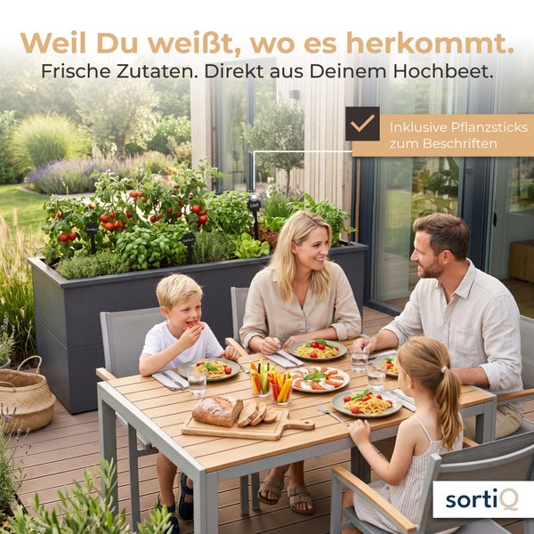 Familie isst auf einer hellen Terrasse neben einem grauen Metall-Hochbeet mit Tomaten und Kräutern. Inklusive Pflanzsticks. sortiQ Logo.