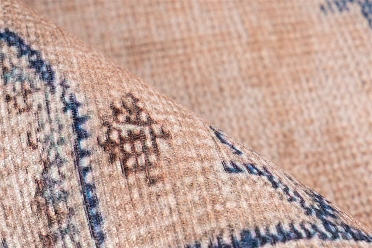 Nahaufnahme eines Teppichs mit geometrischem Muster und strukturierter Oberfläche.