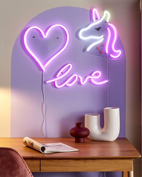 LED-Neon-Wanddekoration Set mit Herz, Einhorn und Love-Schriftzug über einem Schreibtisch aus Holz mit dekorativen Vasen und einem Magazin.