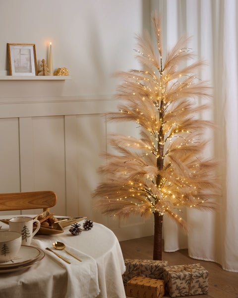 Festlich gedeckter Tisch mit Pampasgras Weihnachtsbaum und Geschenken
