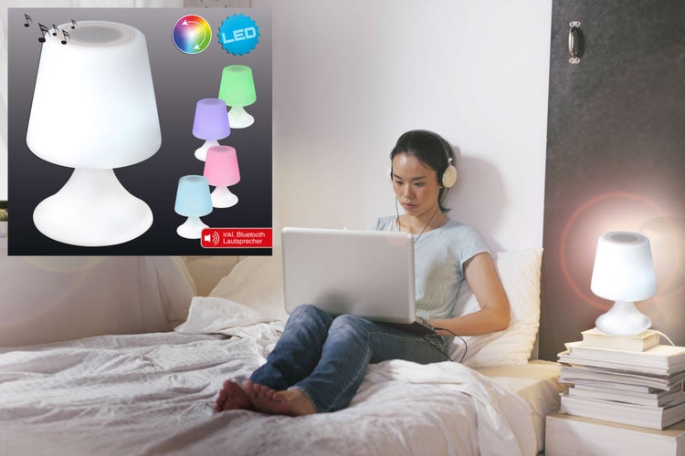 Szene mit einer Frau, die mit einem Laptop im Bett sitzt, neben ihr ein Nachttisch mit einer Lampe inklusive Bluetooth Lautsprecherfunktion.