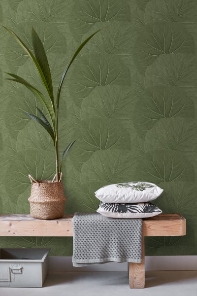 Dekoratives Interieur mit Pflanze, Kissen und Blättertapete