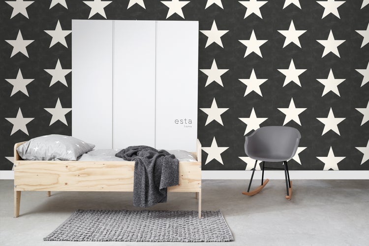 Helles Zimmer mit Holzbett, grauem Teppich und Sternentapete