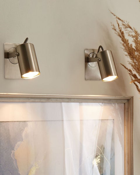 Zwei verstellbare Wandstrahler aus Metall beleuchten ein gerahmtes Bild, modernes Design, helles Licht.