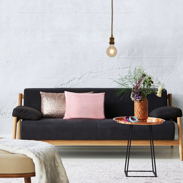 Wohnzimmer mit Sofa, Kissen, Beistelltisch und Dekoration für eine gemütliche Atmosphäre.