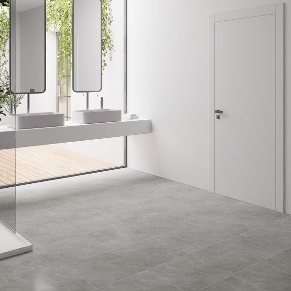 Badezimmer mit Doppelwaschtisch, Spiegeln, Tür und grauem Fliesenboden.