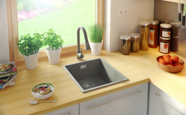 Küchenspüle mit Armatur auf einer Küchentheke neben einem Fenster