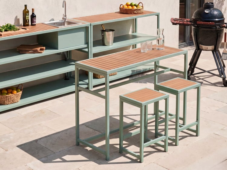 Moderne Außenküche mit Spüle, Regalen, Bartisch und Hockern aus Metall und Holzoptik-Lamellen auf einer Terrasse neben einem Grill.