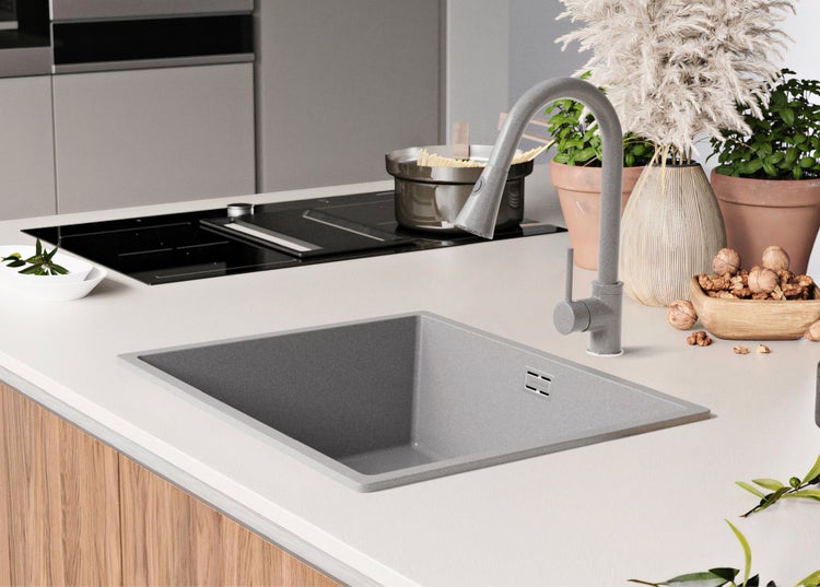 Küchenszene mit Spüle, Wasserhahn, Kochfeld und dekorativen Elementen.