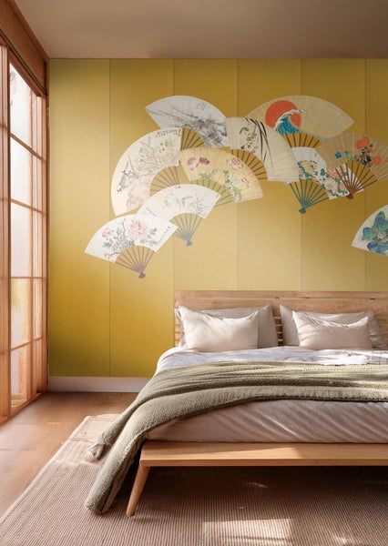 Schlafzimmer mit Bett, Fenster und Wandtapete mit Fächermotiv für eine ruhige Atmosphäre