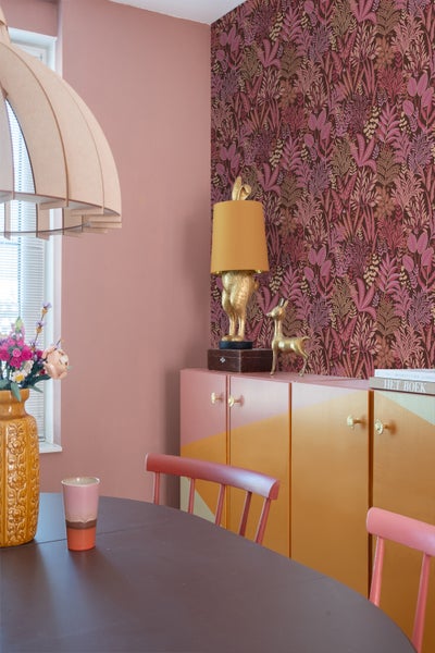 Esszimmer mit Esstisch, Stühlen, Sideboard, Lampe und floraler Tapete