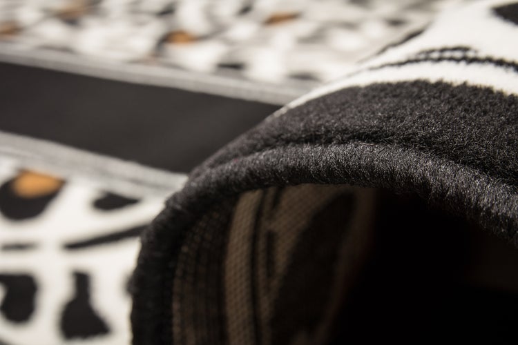 Nahaufnahme eines Teppichs mit Leopardenmuster und geketteltem Rand.