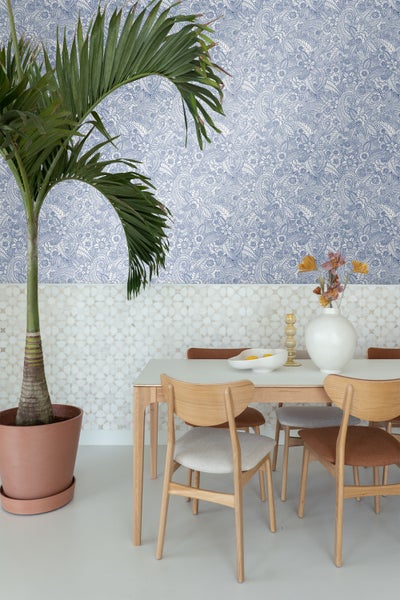 Esszimmer mit Esstisch, Stühlen, Palme im Topf und gemusterter Tapete