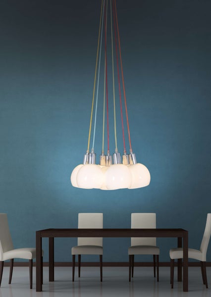 Mehrflammige Pendelleuchte im Wohnzimmer mit farbigen Kabeln und weißen Lampenschirmen.