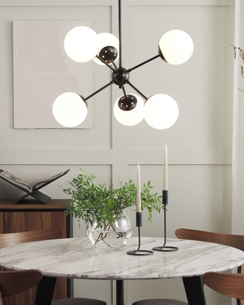 Innenaufnahme eines Esszimmers mit einem Esstisch mit Dekorationen und einer Hängelampe