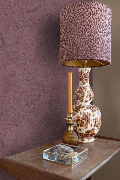 Dekoratives Stillleben mit Lampe, Kerze, Dekoration und gemusterter Tapete auf einem Tisch