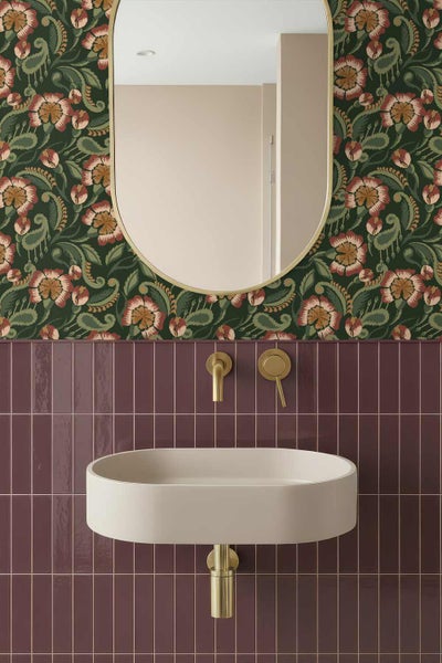 Modernes Badezimmer mit geblümter Tapete, vertikalen Wandfliesen, einem ovalen Waschbecken, goldfarbener Wandarmatur und einem ovalen Spiegel.