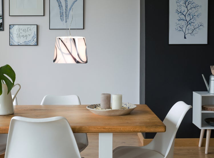 Esszimmer mit Holztisch, weißen Stühlen und Pendelleuchte