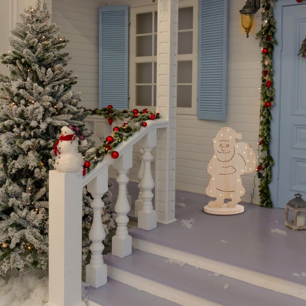 Dekorierte Veranda mit Weihnachtsmann aus Holz, Schneemann und Weihnachtsbaum