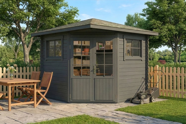 Graues Gartenhaus aus Holz in Eckform mit Doppelflügeltür auf Steinterrasse mit Gartenmöbeln und Rasenmäher in einer hellen Gartenumgebung.