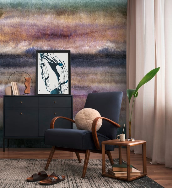 Modernes Wohnzimmer mit einer Fototapete mit abstraktem, horizontalem Farbmuster, einem Polstersessel und einem Sideboard.