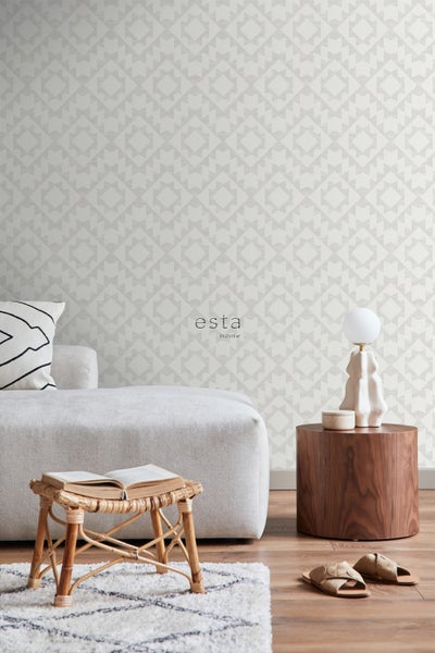 Wohnzimmer mit geometrischer Tapete, Sofa, Lampe und Holzhocker