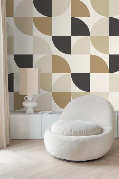 Wohnzimmer mit geometrischer Tapete, Sessel und Lampe