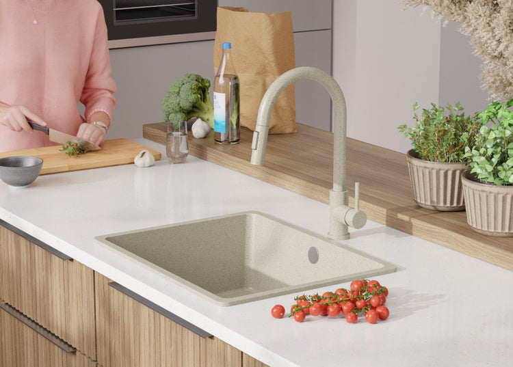 Küchenszene mit Spüle, Armatur, Gemüse und Kräutern.