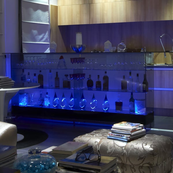 Bar mit Glasböden, Flaschen und Gläsern in einem Wohnzimmer