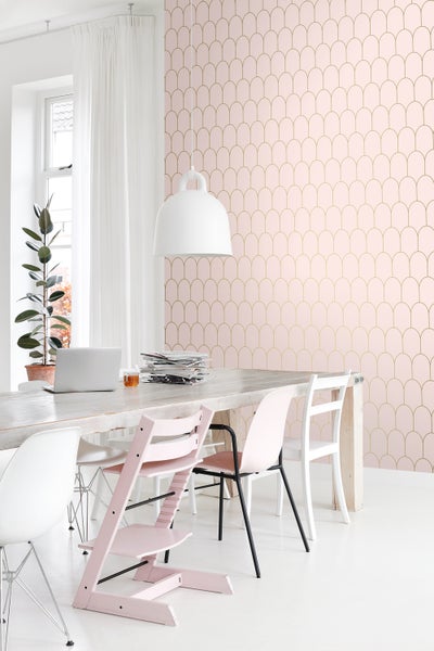 Ein Esszimmer mit einem Holztisch, Stühlen und einer gemusterten Tapete