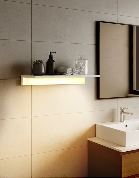 Modernes Badezimmer mit Waschtisch, Spiegel und beleuchtetem Regal