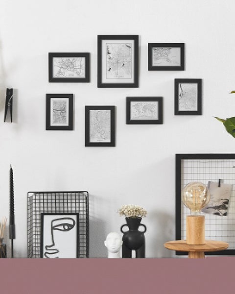 Dekorative Wand mit Bilderrahmen, grafischen Elementen und Wohnaccessoires