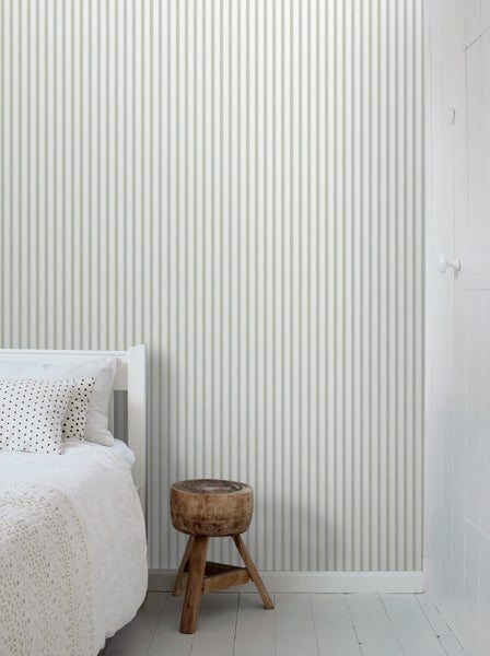 Wohnzimmer mit gestreifter Tapete, Sofa, Beistelltisch und Zimmerpflanze für eine gemütliche Atmosphäre