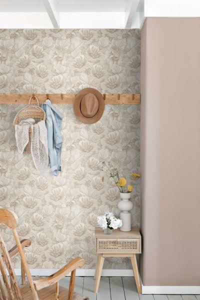 Wohnraum mit floraler Vliestapete, Holzgarderobe, Beistelltisch mit Vase und Blumen, Einrichtung im natürlichen Landhausstil.