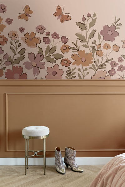 Dekorativer Raum mit geblümter Tapete, Hocker mit Polster und Glitzerstiefeln.