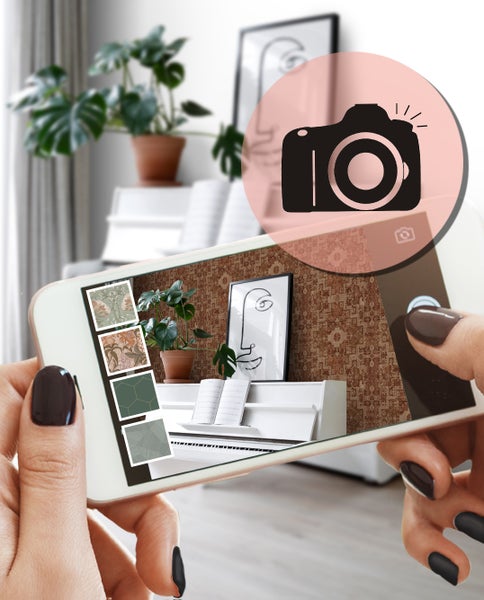 Ein Smartphone zeigt eine Raumansicht mit verschiedenen Tapetendesigns zur Auswahl.