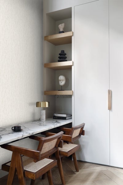 Büroarbeitsplatz mit Tisch, Stühlen und Regalen im modernen Design.