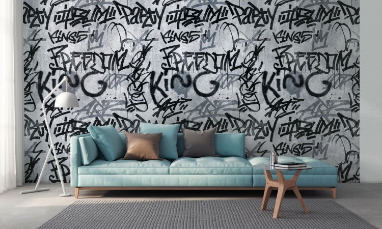 Wohnraum mit Sofa vor einer Wandtapete mit Graffiti-Motiv