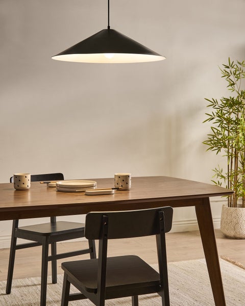 Esstisch mit Geschirr, Stühlen und Hängelampe in einem Esszimmer.