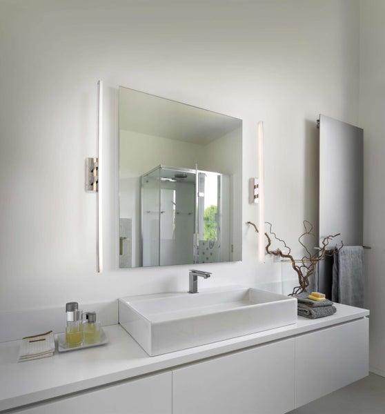 Modernes Badezimmer mit Waschbecken, Spiegel, Beleuchtung und Accessoires.