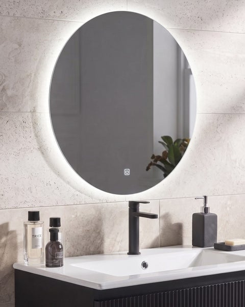 Runder LED Badezimmerspiegel mit integrierter Touchsteuerung über einem Waschbecken mit moderner Waschtischarmatur in einem gefliesten Bad.