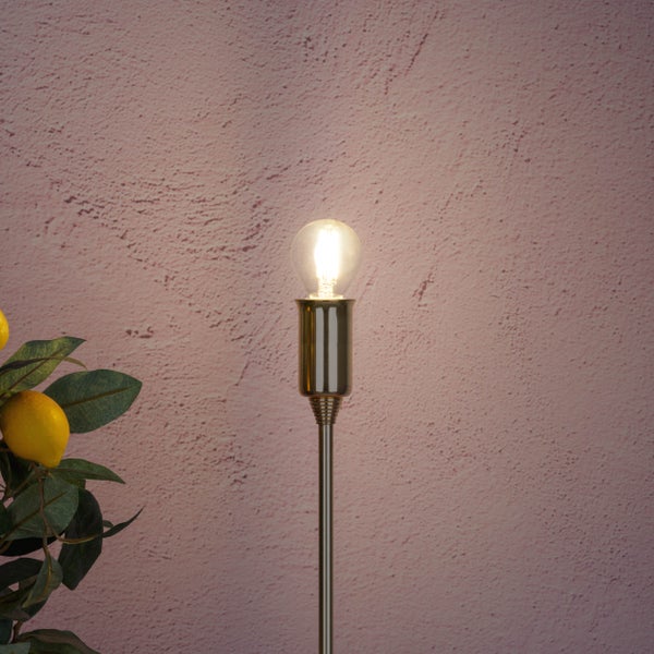 Dekorative Stehlampe mit eingeschalteter Glühbirne und Zitronenzweig