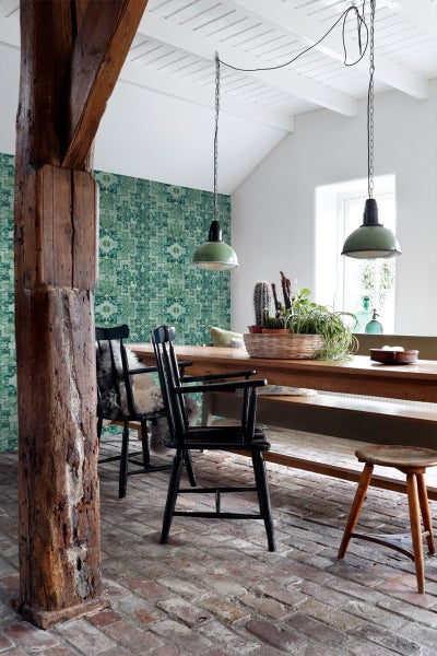 Esszimmer mit Esstisch, Stühlen, Lampe und gemusterter Tapete