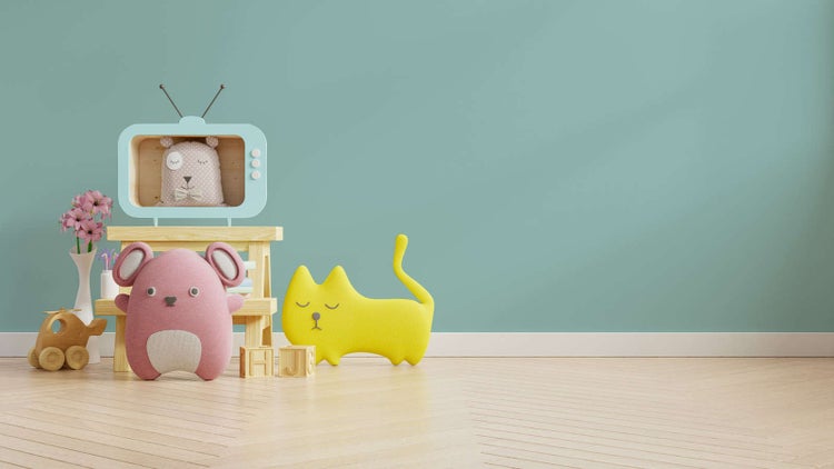 Hell eingerichtetes Kinderzimmer mit mintgrüner Wand, hellem Holzboden, Holzmöbeln und verschiedenen Plüschtieren und Holzspielzeugen.