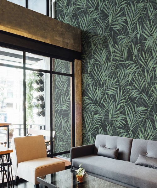 Wohnzimmer mit Palmenblatt-Tapete, Sofa und Sessel