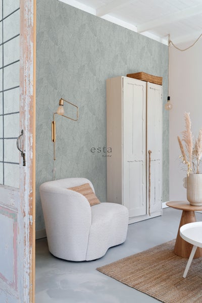 Helles Wohnzimmer mit Blattmuster-Tapete, Sessel, Schrank und Teppich