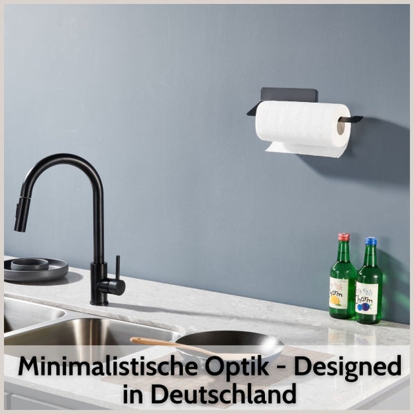 Wandmontierter Papierrollenhalter aus Metall in einer modernen Küche mit Spülbecken und Wasserhahn.