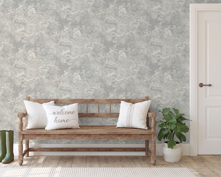 Eingangsbereich mit floral gemusterter Tapete, Holzbank mit Kissen, Zimmerpflanze und Gummistiefeln
