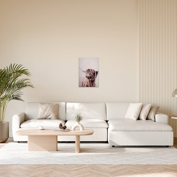 Wohnzimmer mit Sofa und Wandbild eines Hochlandrindes