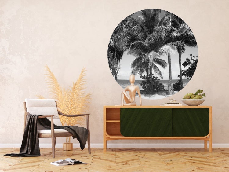 Wohnzimmer mit Sessel, Kommode und Wanddekoration mit Palmenmotiv in Schwarzweiß